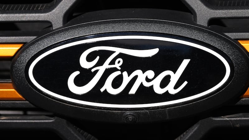 FILE - A Ford logo is seen on the grille of an unsold vehicle at a Ford dealership, Nov. 2,...