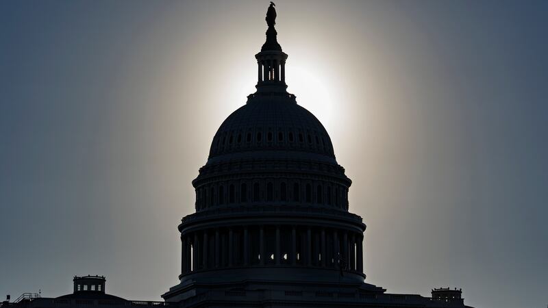 La silueta del Capitolio de Estados Unidos, Iluminada por el brillo del sol matutino, en el...