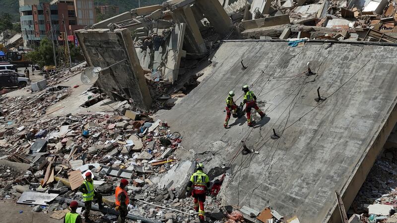 Equipos de rescate del Ejército mexicano buscan a personas atrapadas en edificios derrumbados...