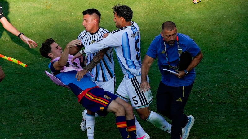 El jugador español Gavi, a la izquierda, es empujado en un choque con el jugador argentino...