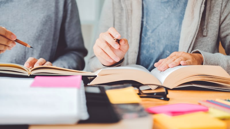 High school or college students studying and reading together in library
