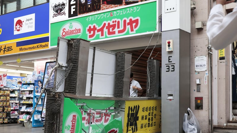 Un cartel de un restaurante se ve caído en el suelo tras un sismo en Kumamoto en la isla de...