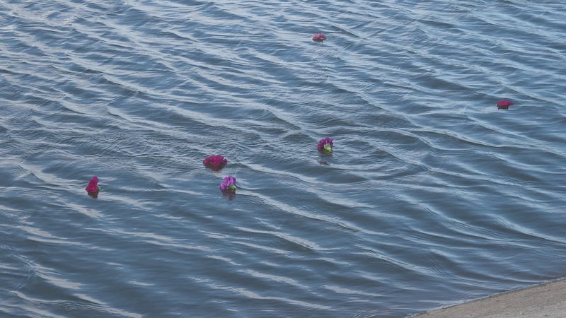 Marie Detty holds Flowers On The Water memorial for domestic violence victims