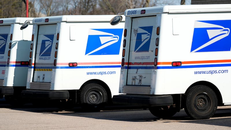 FILE - U.S. Postal Service trucks park outside a post office in Wheeling, Ill., Monday, Jan....