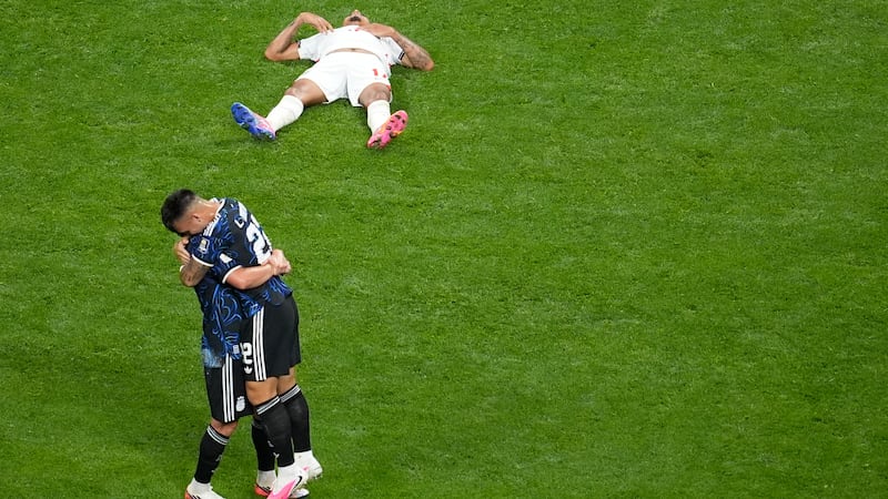 Argentina's Lautaro Martinez (22), right, hugs a teammate at the end of the World Cup...