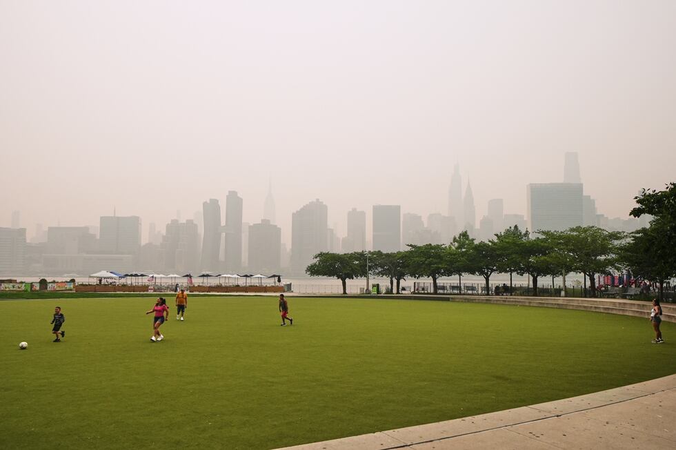 Un grupo de personas juega en el Hunter's Point South Park Athletic Field. Al fondo se...