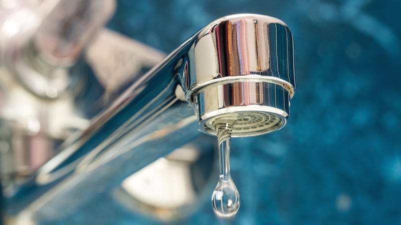 A drop of water drips from a leaky faucet.